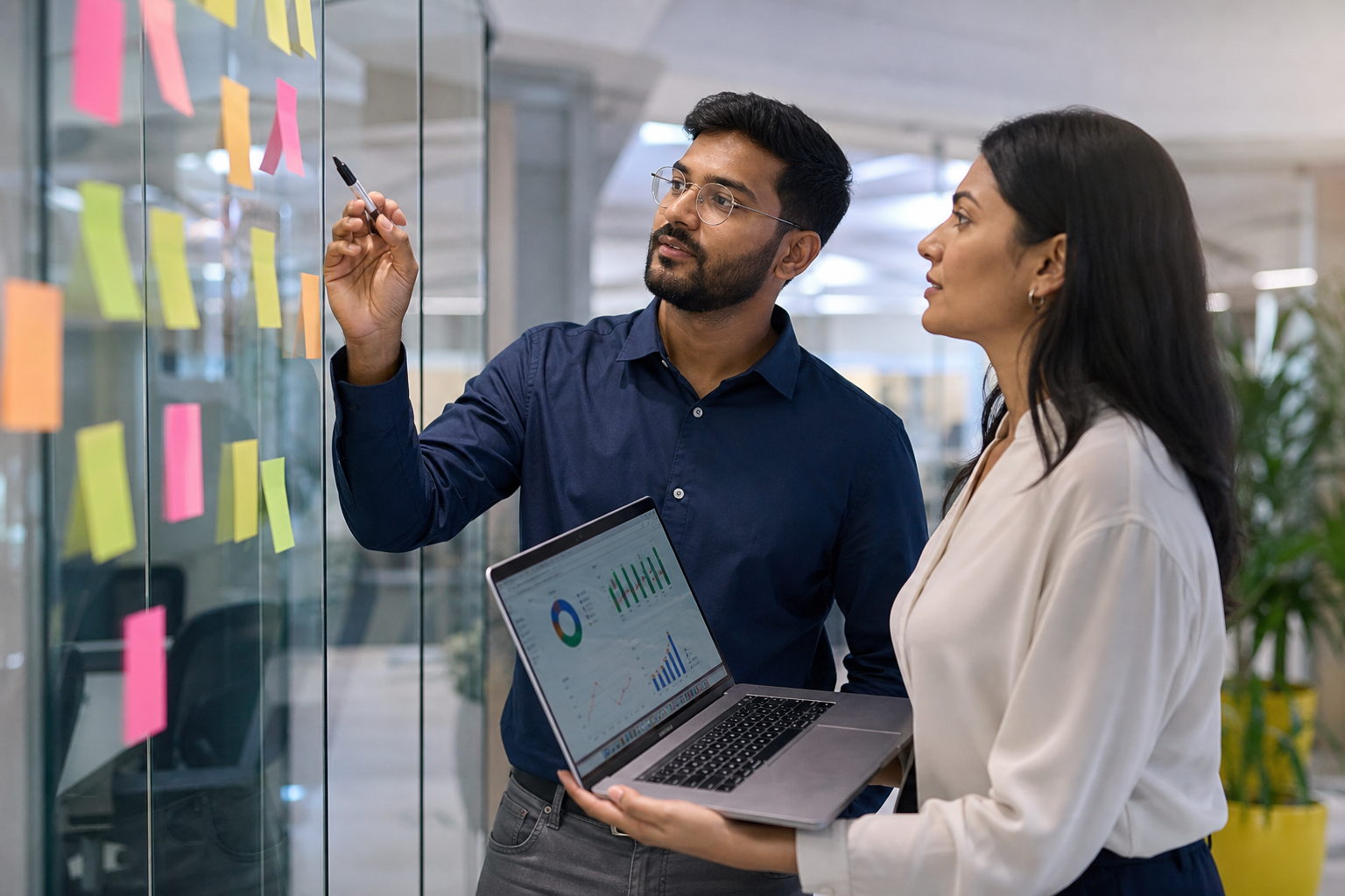 Indian founder and ops manager reviewing automation ROI together in an office.